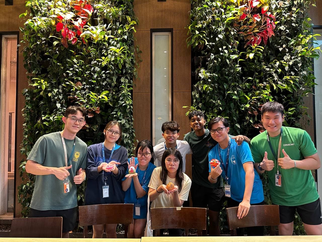 NUS College friends in front of a green wall