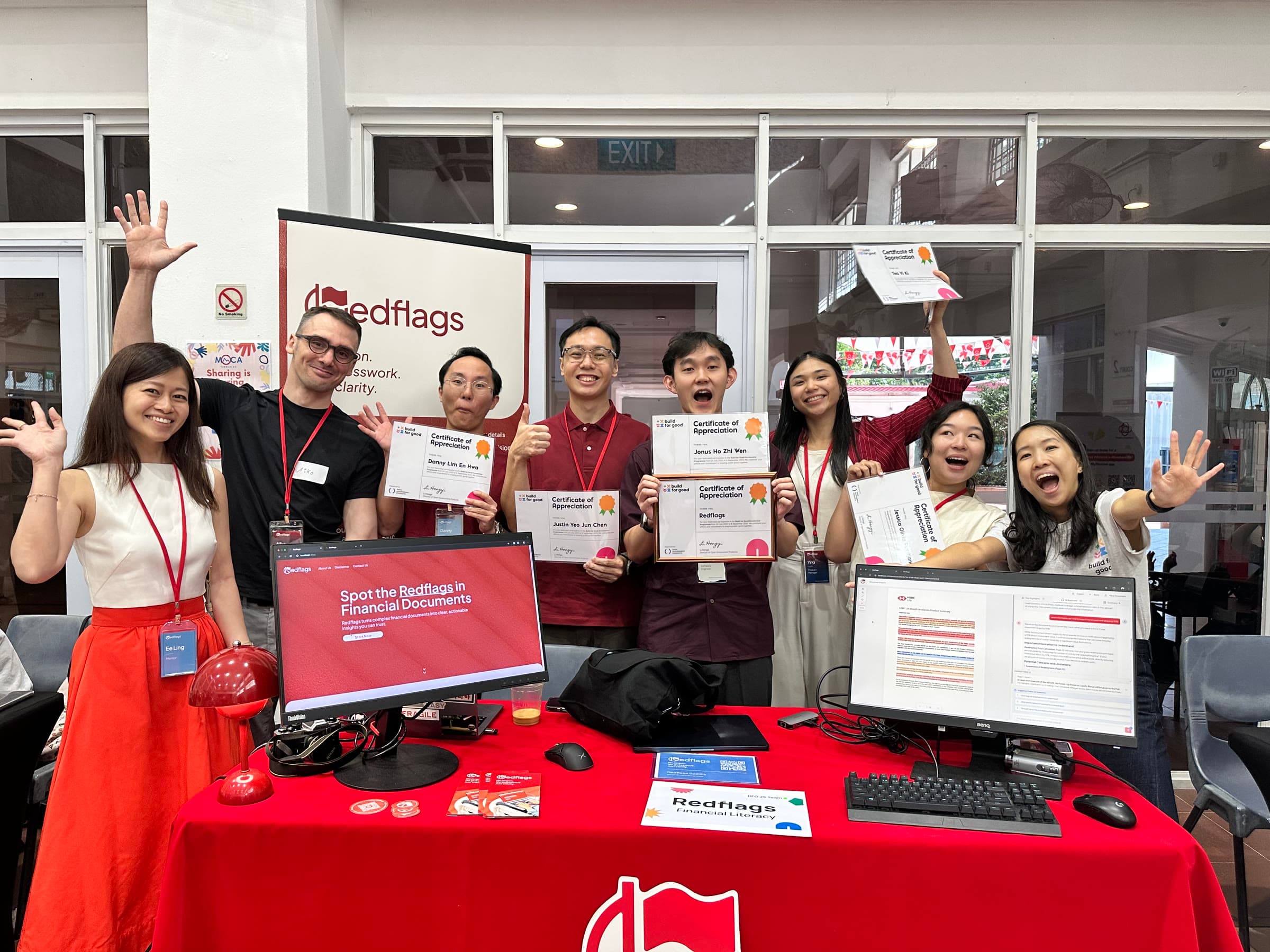 The Redflags team at their booth, holding their certificates